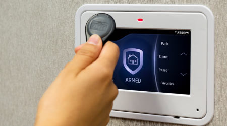 Armed Sherlock security panel with a key fob held to the reader